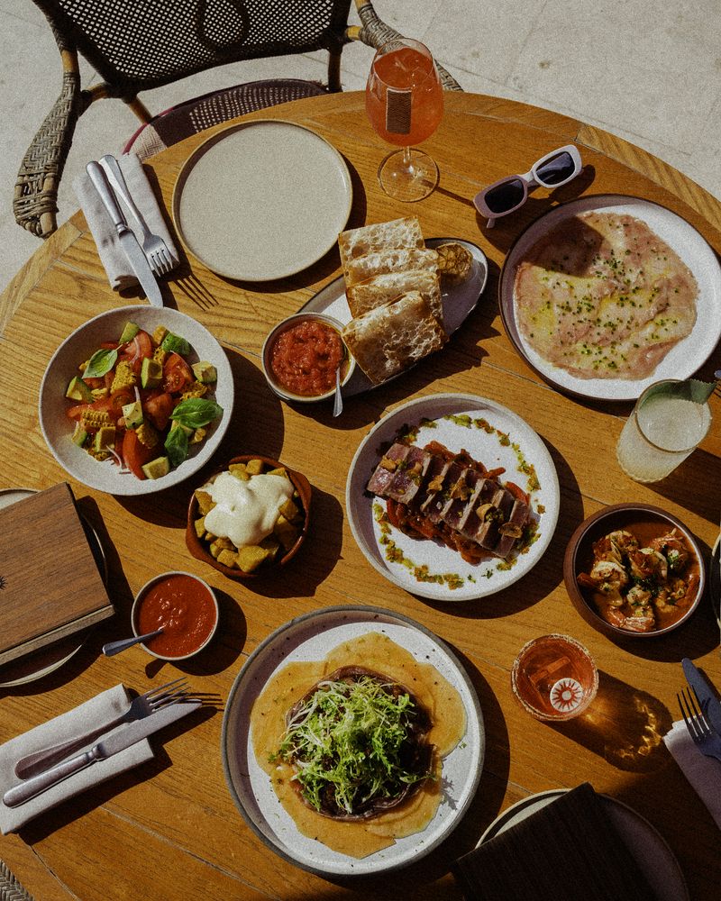 Mesa con tapas españolas: pan con tomate, carpaccio, atún, gambas al ajillo y patatas bravas